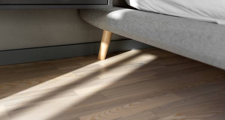 close up bedroom flooring grey bed