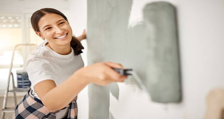 close up woman painting green wall