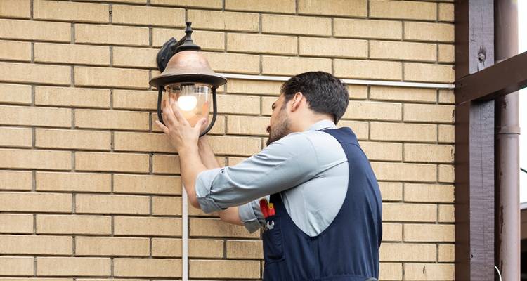 Electrician fitting outside light