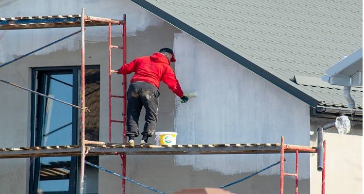man on scaffolding painting