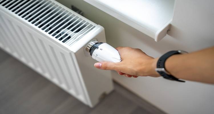 hand on radiator thermostat