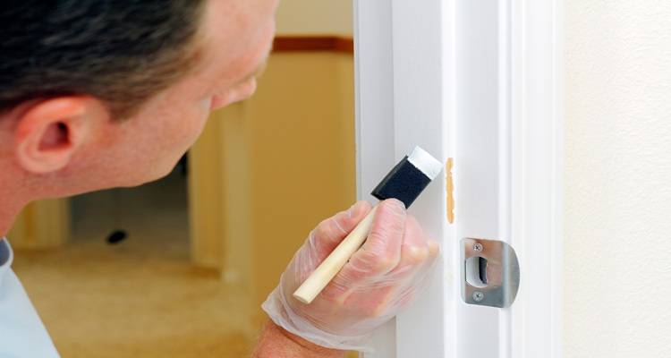 man touching up door paintwork