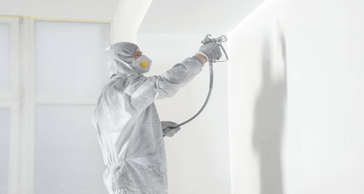 man spraying white walls