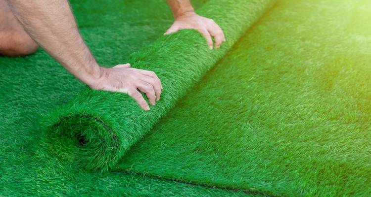 hands roll fake grass
