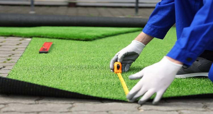 hands installing fake grass