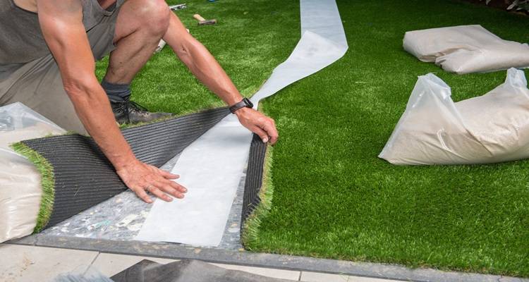 hands laying fake grass