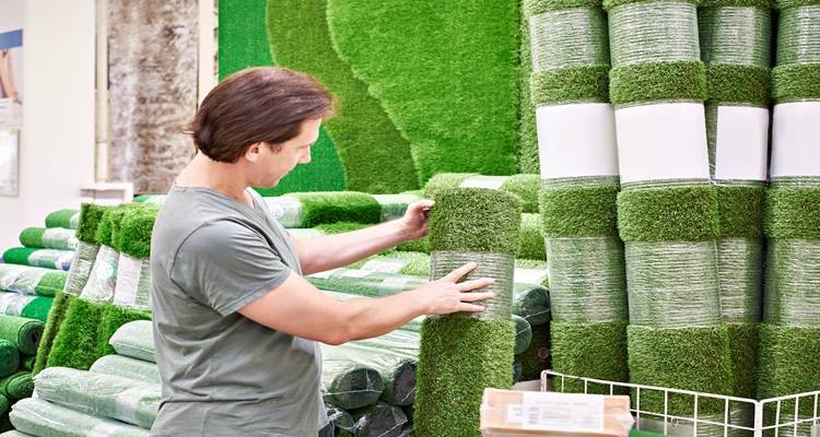 man rolls of fake grass