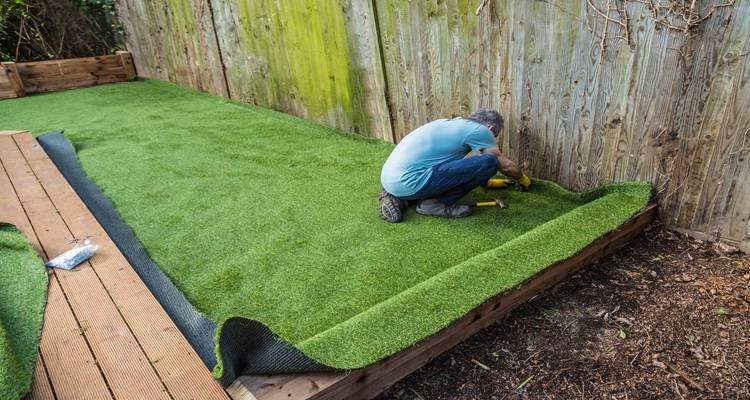 man blue t shirt installing grass