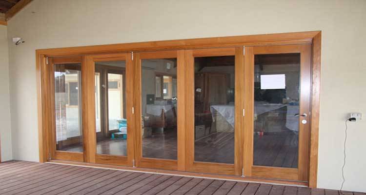 timber bifold door installation in the interior of a UK property with five glass panels