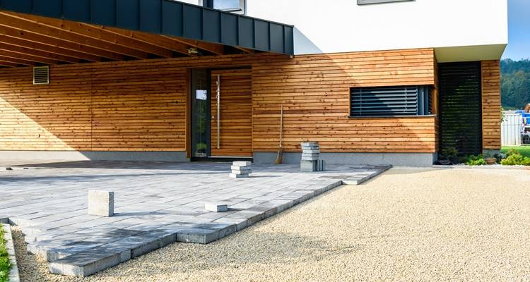 grey pavers clad wood house behind