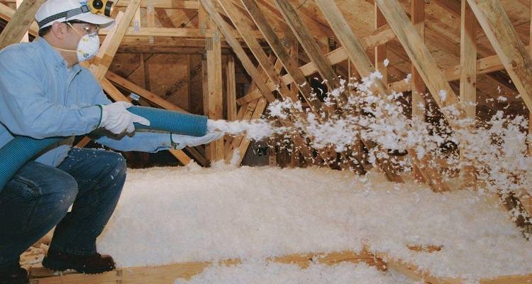 Loose-fill insulation being installed in a loft space