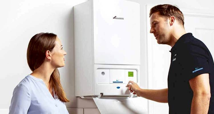 heating engineer explaining to a woman how new boiler installation works