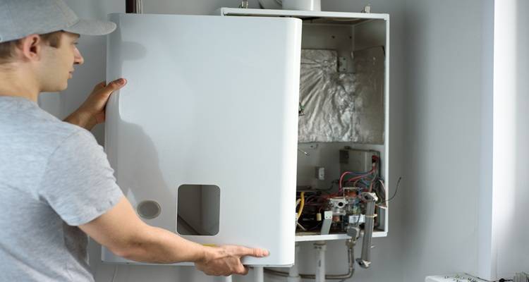 man in front of boiler with cover