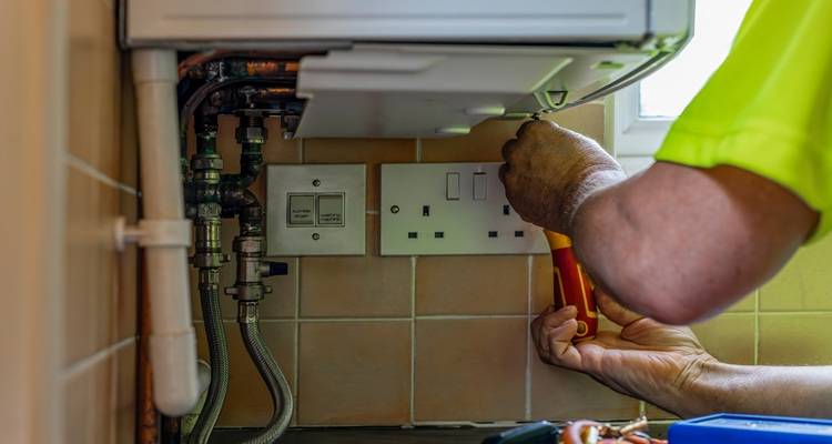 man fixing boiler plug sockets