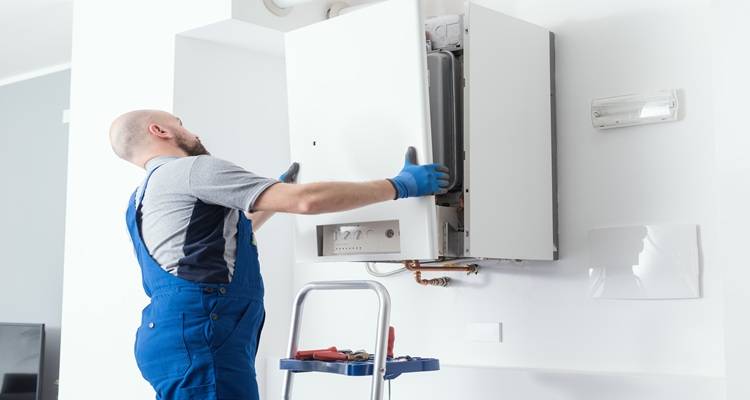 man putting cover back on boiler