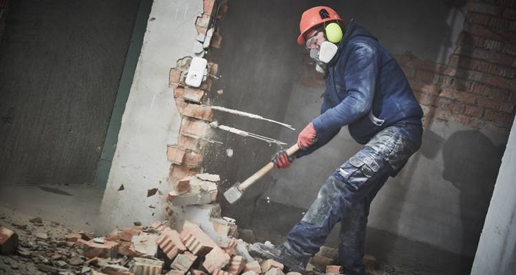man demolishing wall