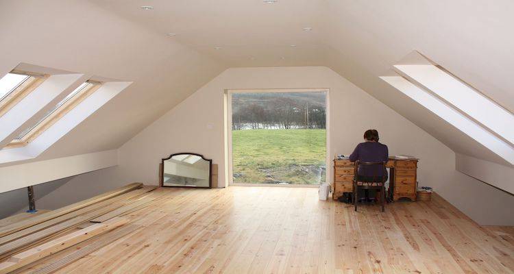 person working in a bungalow loft conversion office with a large window