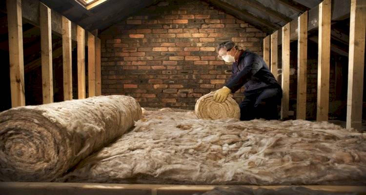 cavity wall insulation cost guide &mdash; tradesperson installing insulation in a loft