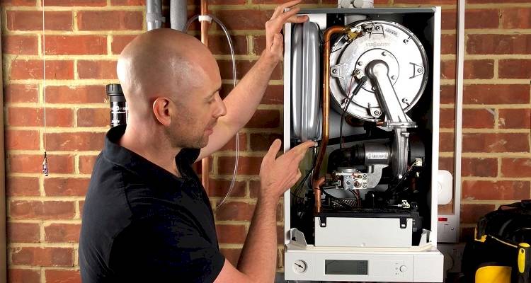 boiler installation cost guide &mdash; tradesperson conducting a boiler service