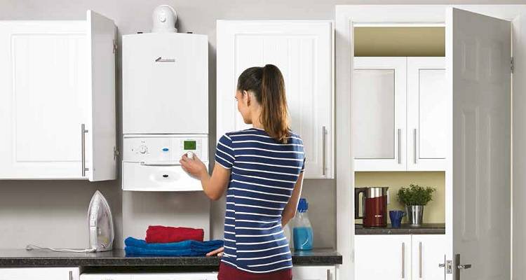 boiler installation cost guide &mdash; person changing the settings on a new boiler