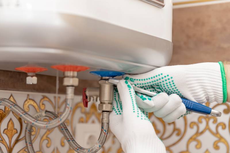 closeup of heating engineer equipment and open boiler while performing a boiler service