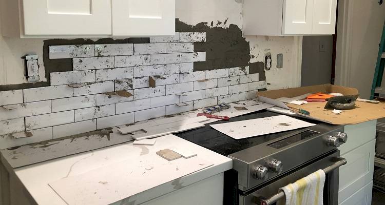 kitchen wall tiles in the process of being installed behind a cooker