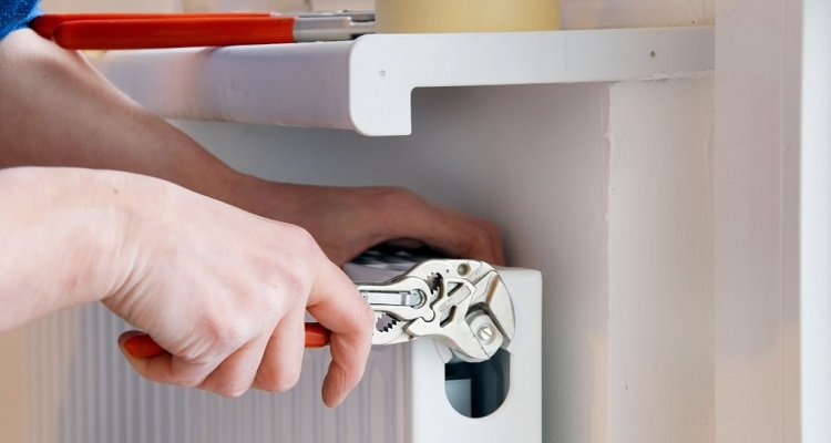 tradesperson fixing radiator