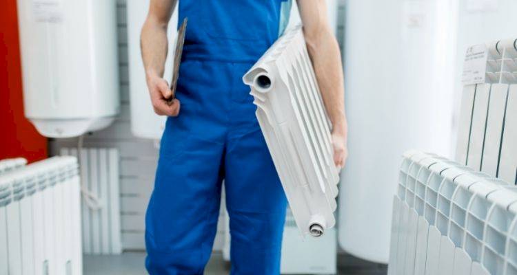 tradesperson holding a radiator