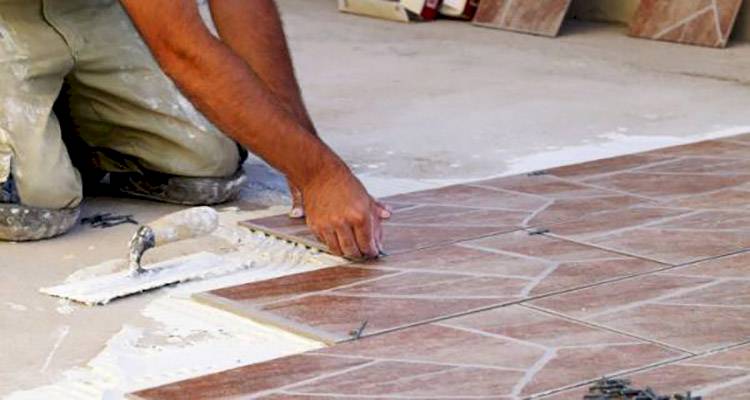 tiler laying mosacic floor tiles