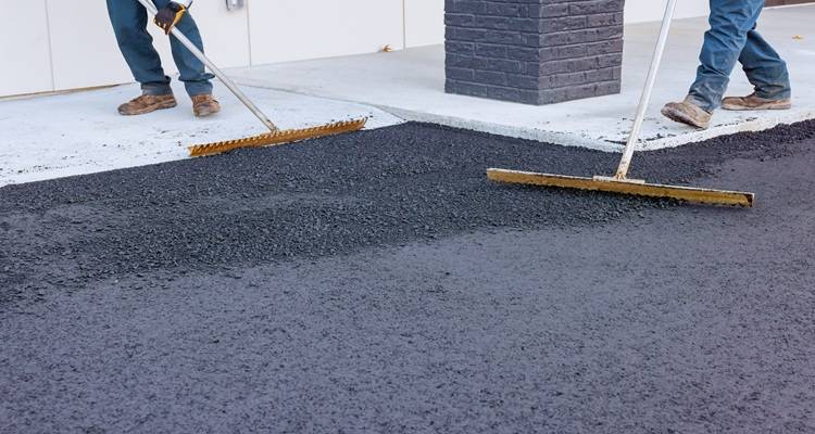 tarmac being raked by two people