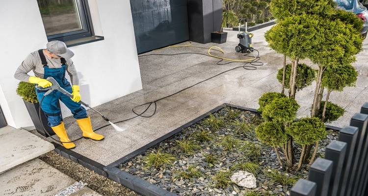 person yellow wellies cleaning drive