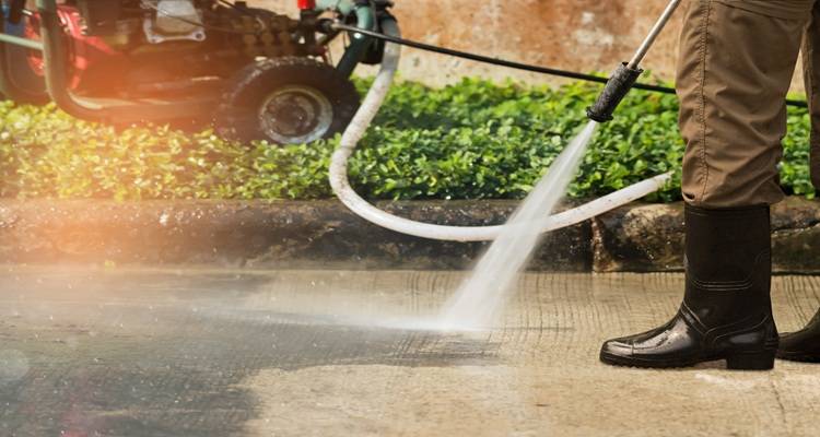 driveway being jet washed black wellies