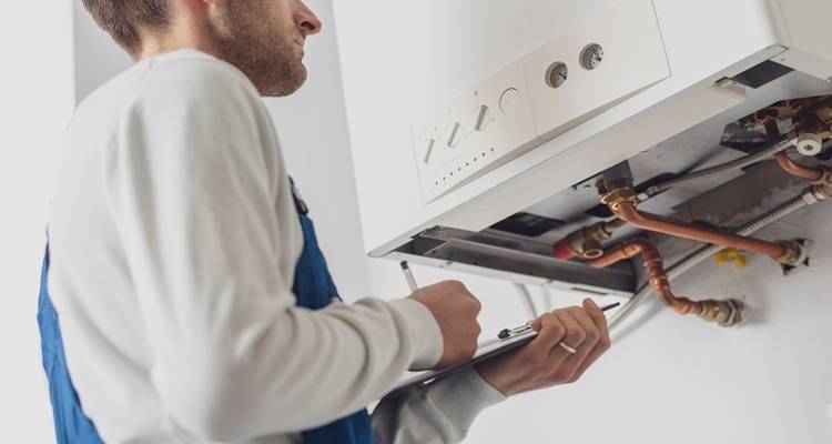 man servicing boiler