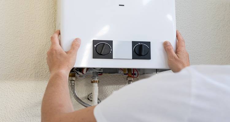 man&rsquo;s hands on boiler control dials