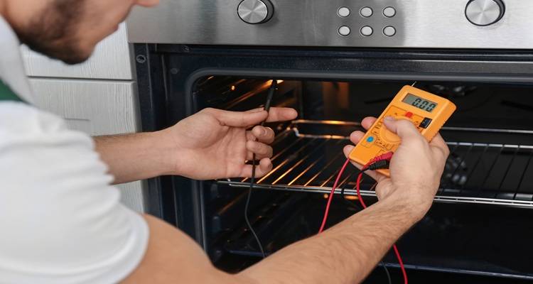 man fixing oven