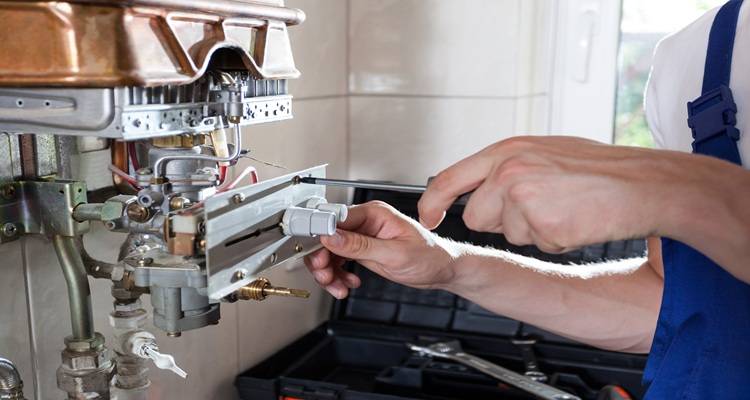 hands fixing boiler