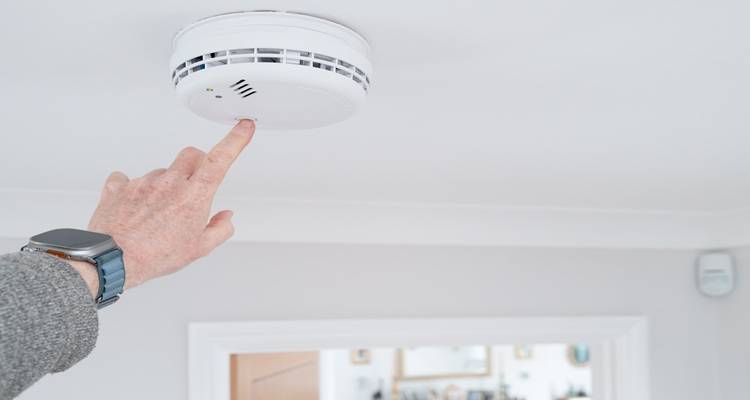carbon monoxide detector hand testing it