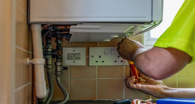 hand fixing boiler from underneath
