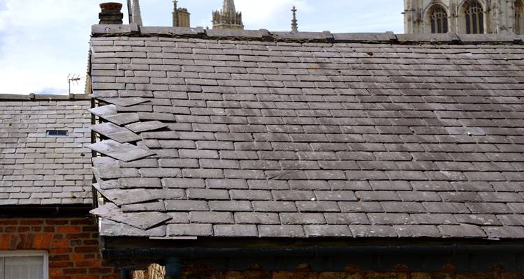 Grey slate roof with fallen slates