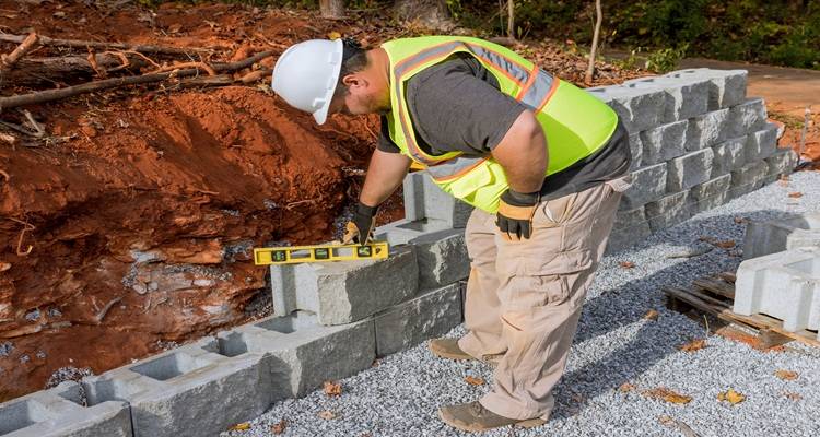 man building grey wall