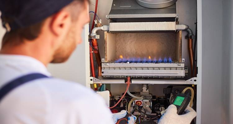 man in front of gas boiler open
