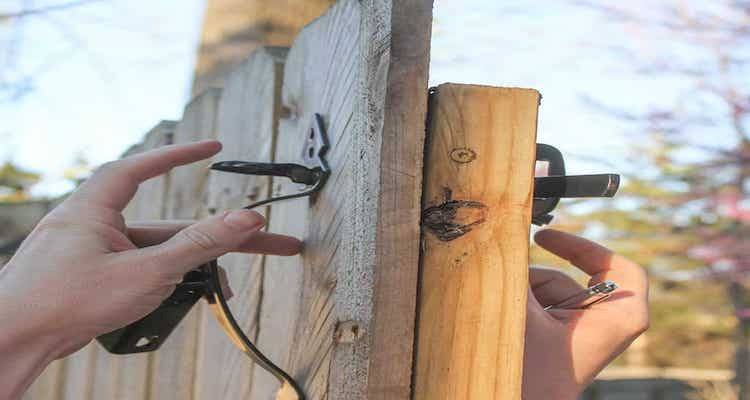 tradesperson finishing up the installation of a gate