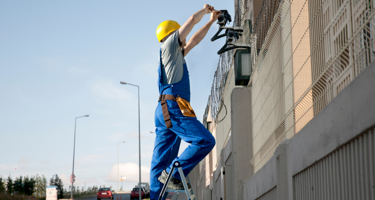 tradesperson installing CCTV outside