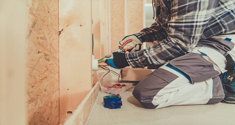man kneeling in front of wires
