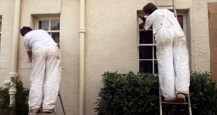 two painters painting house exterior