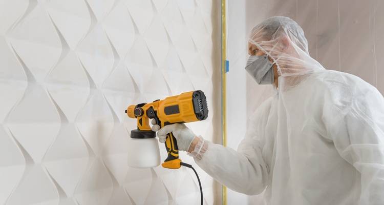 man spraying wall