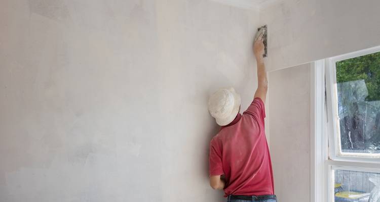 man skimming wall