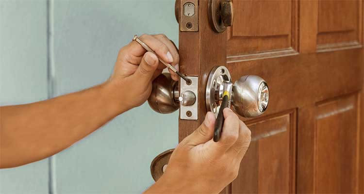 tradesperson changing the locks on a front door