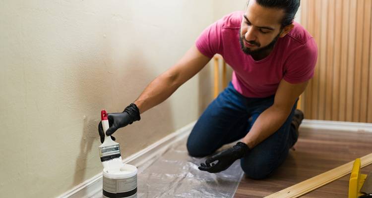 man red shirt painting skirting