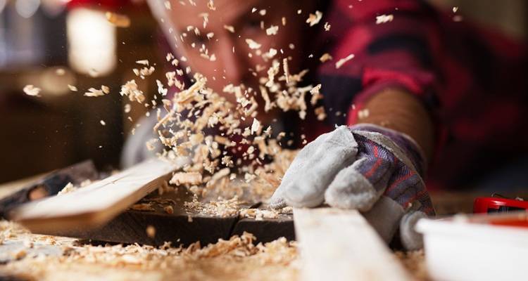 carpenter blowing sawdust